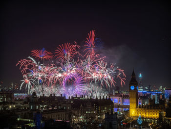 High angle view of firework display at night