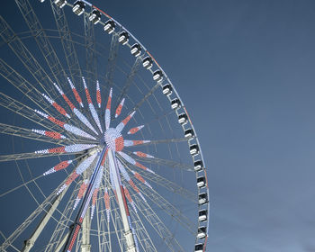 Low angle view of ferris wheel against blue sky