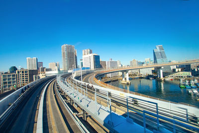 View of bridge and buildings against clear blue sky