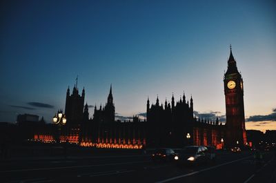 Silhouette of clock tower in city at night