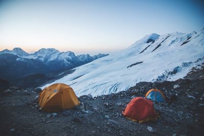 Tent on field against snowcapped mountains