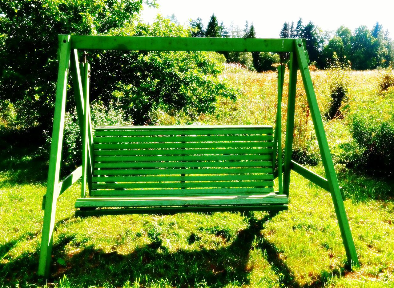 grass, tree, green color, bench, absence, empty, grassy, field, growth, park - man made space, chair, plant, park bench, sunlight, playground, nature, tranquility, lawn, day, railing