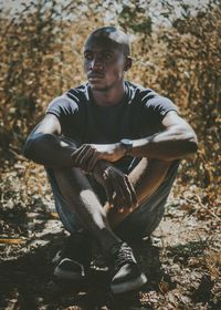 Young man sitting in forest