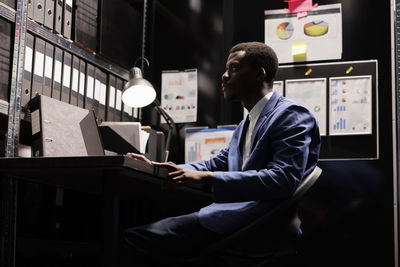 Rear view of man using digital tablet in office