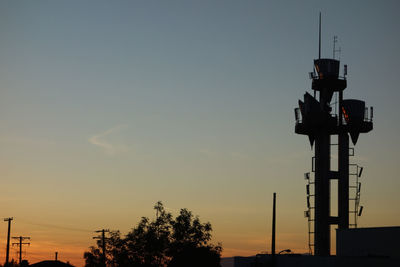 Silhouette crane against sky during sunset