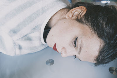 Close-up portrait of woman lying on bed