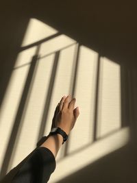 Low section of woman with shadow on wall