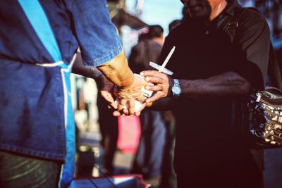 Midsection of man buying food and drink from vendor