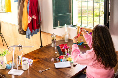 High angle view of mother and daughter sitting on table