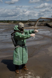 Man photographing with umbrella on shore