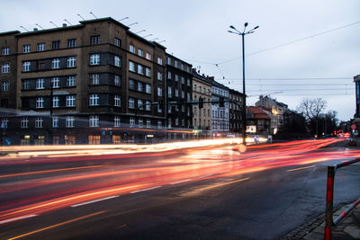 Light trails on road against buildings in city