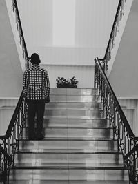 Rear view of man standing on staircase