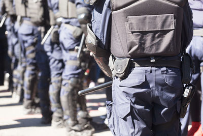 Police force standing on street during sunny day