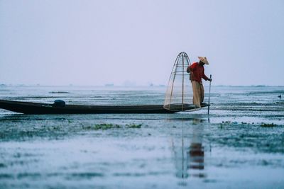 Woman in sea against clear sky