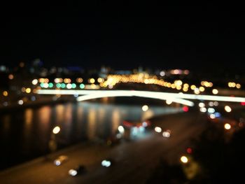 Road passing through illuminated city at night