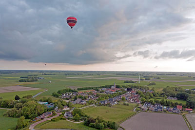 Aerial from a flying hot air balloon in the countryside from the netherlands at sunset