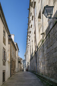 Narrow street amidst buildings against clear sky