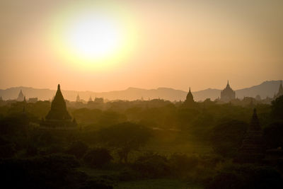 Temples against clear sky during sunset