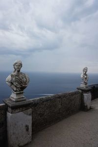 Statue by sea against sky