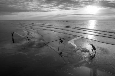 Fishermen working with nets at beach