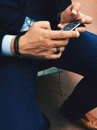 Midsection of man using mobile phone