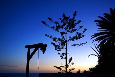 Low angle view of silhouette trees against sky at dusk