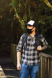 Man wearing mask standing in forest