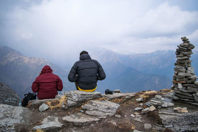 Rear view of people on rock against sky