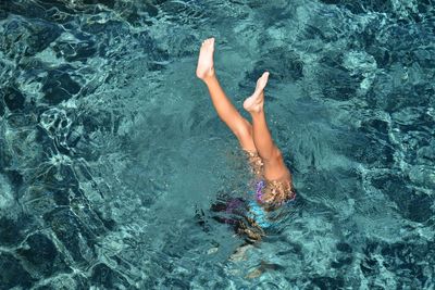 Woman with feet up swimming in sea