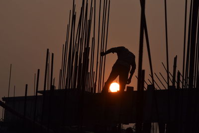 Low angle view of silhouette man against orange sky