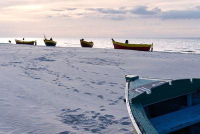 Boat moored on beach against sky