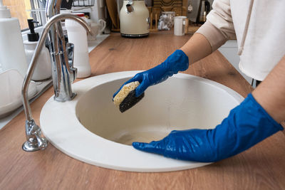 Midsection of man washing hands in bathroom