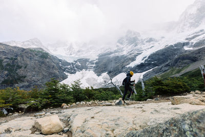 Man walking on rocks against mountains