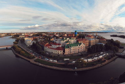 High angle view of city by river against sky