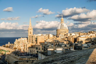 Panoramic view of townscape by sea against sky in city