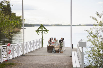 Family having midsummer dinner by lake