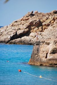 Scenic view of rock formation in sea against sky