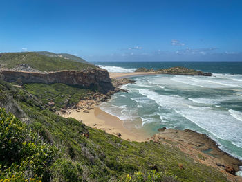 Scenic view of beach against blue sky