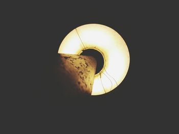 Close-up of illuminated lamp over black background