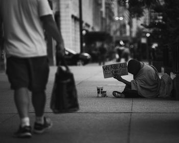 Low section of men sitting on street