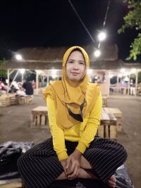 Portrait of smiling young woman sitting outdoors