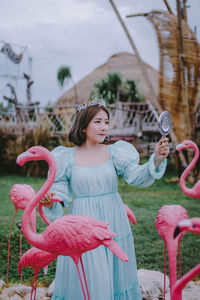 Portrait of woman with pink hair standing against plants