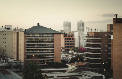 Buildings in city against clear sky