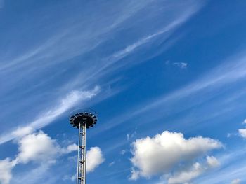 Low angle view of amusement park ride against blue sky