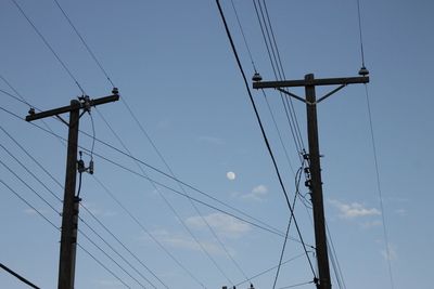 Low angle view of silhouette electricity pylon against sky