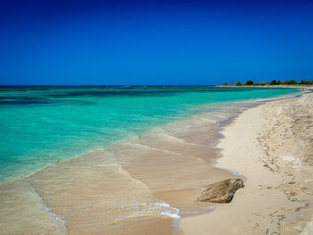 Scenic view of beach against blue sky