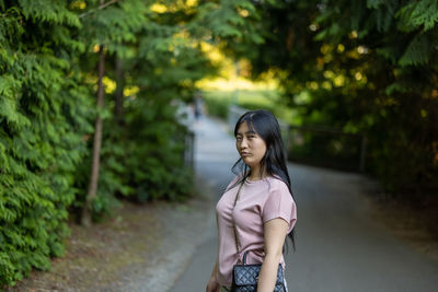 Woman standing by tree against plants