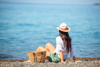 Woman looking at view of people sitting on beach