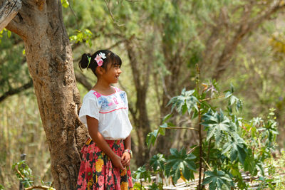 Full length of woman standing by tree