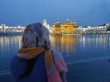 Rear view of woman looking at river against sky